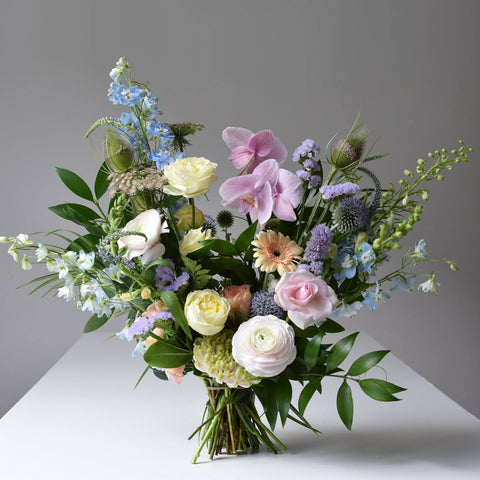 A large flower bouquet using a wide variety of blooms. The palette is pastels.