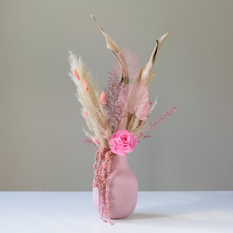Gorgeous pink and neutral dried arrangement in a light pink textured ceramic vase