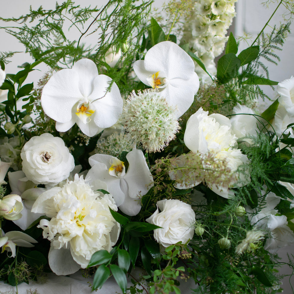 A close up of white flowers in a sympathy arrangement.