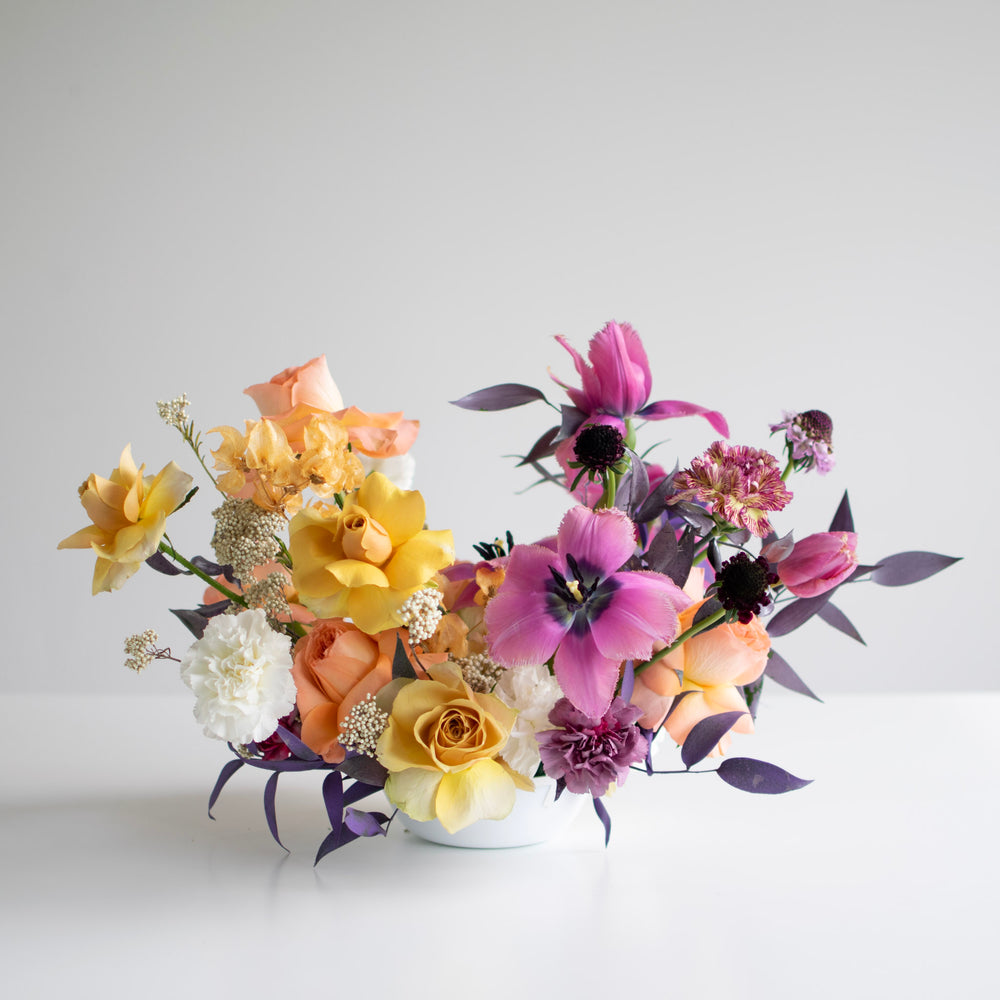 Flexed tulips and roses in a magenta and yellow color palette.