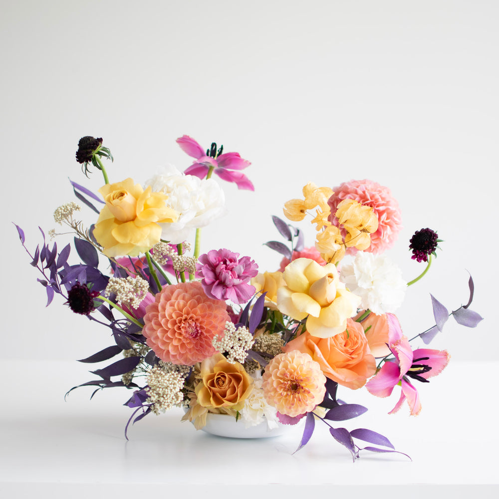 A low sitting centrepiece with bright colours and flexed tulips.