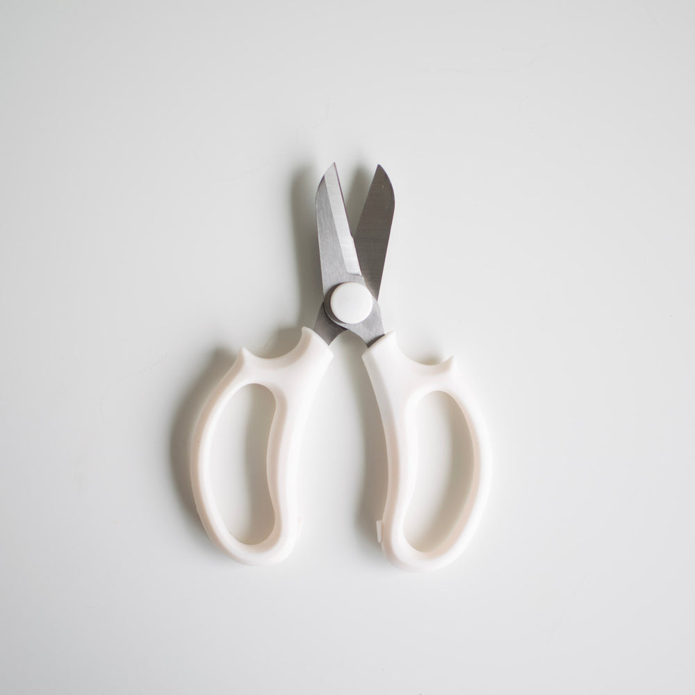 White floral clippers with metal shears against a white background.