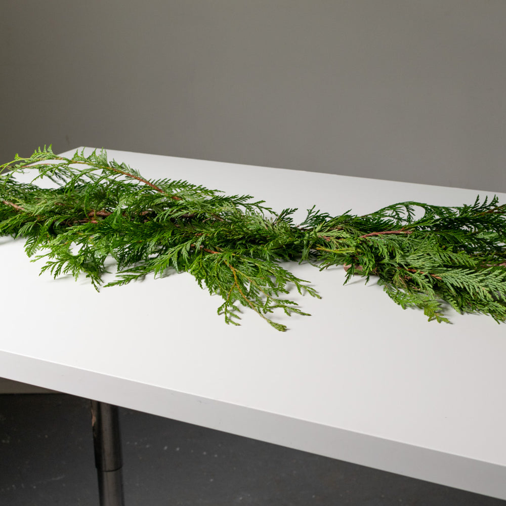 Simple cedar garland on a white table.