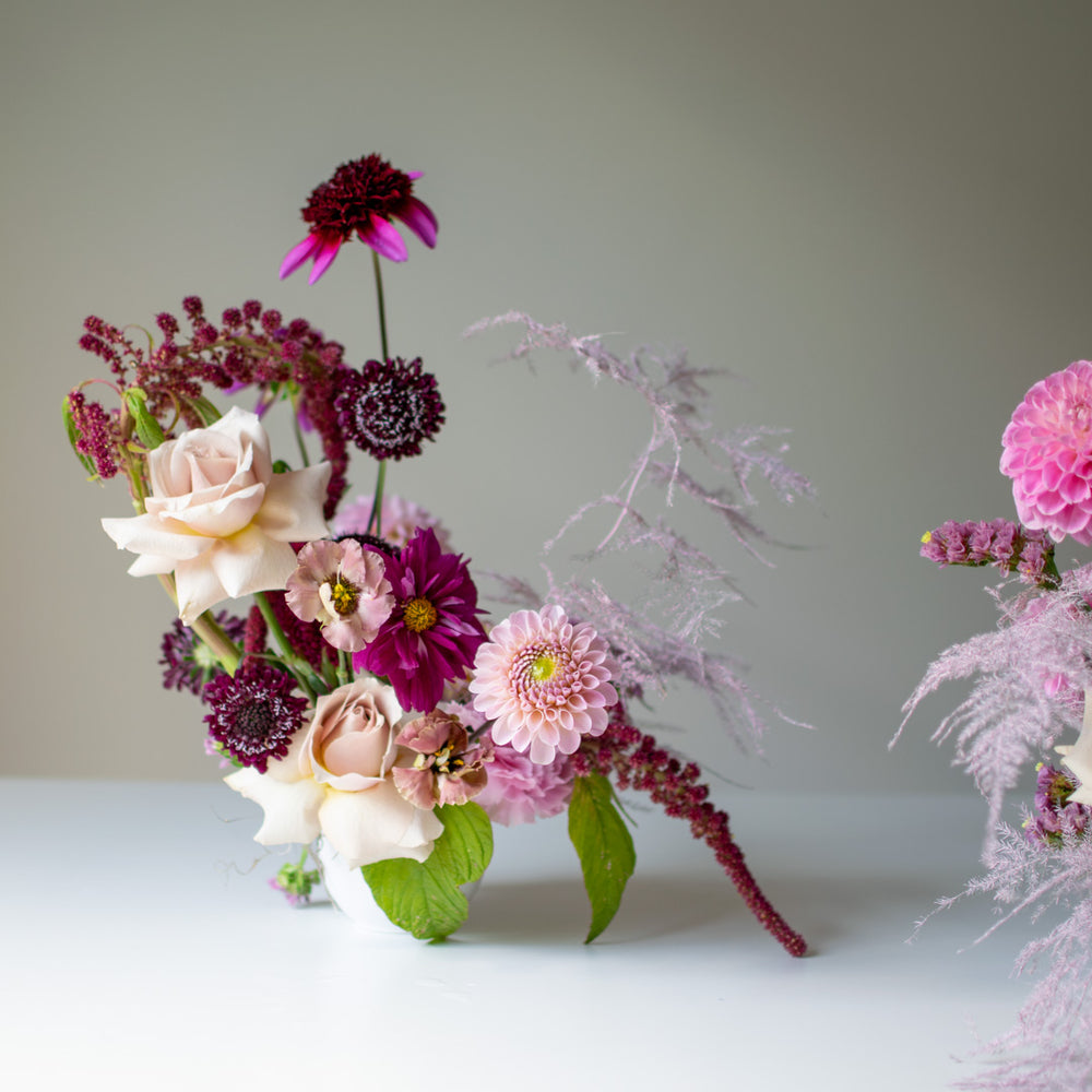 A moody flower arrangement using pink tones and cream accents.