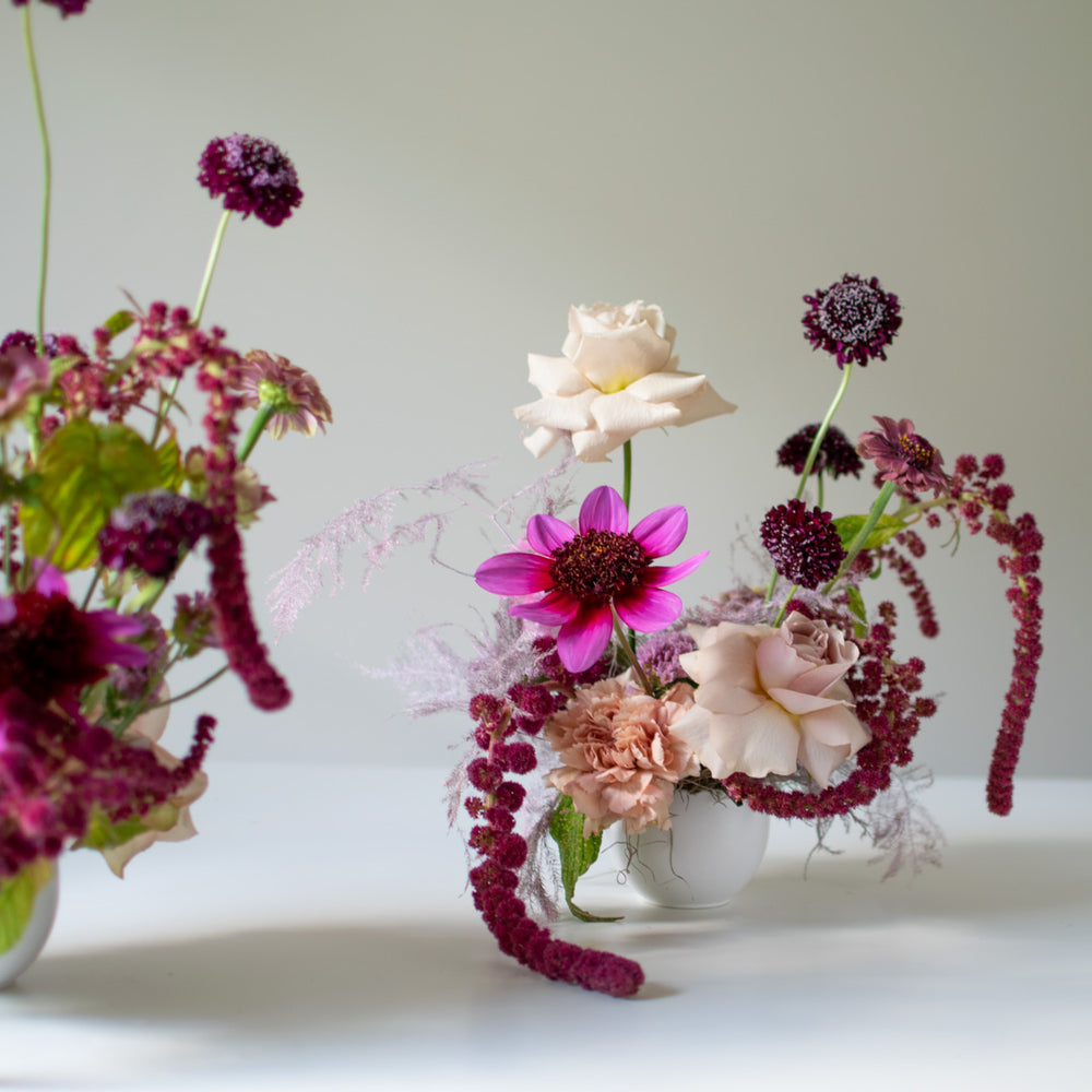 A small flower bouquet in a mini white ceramic vase.