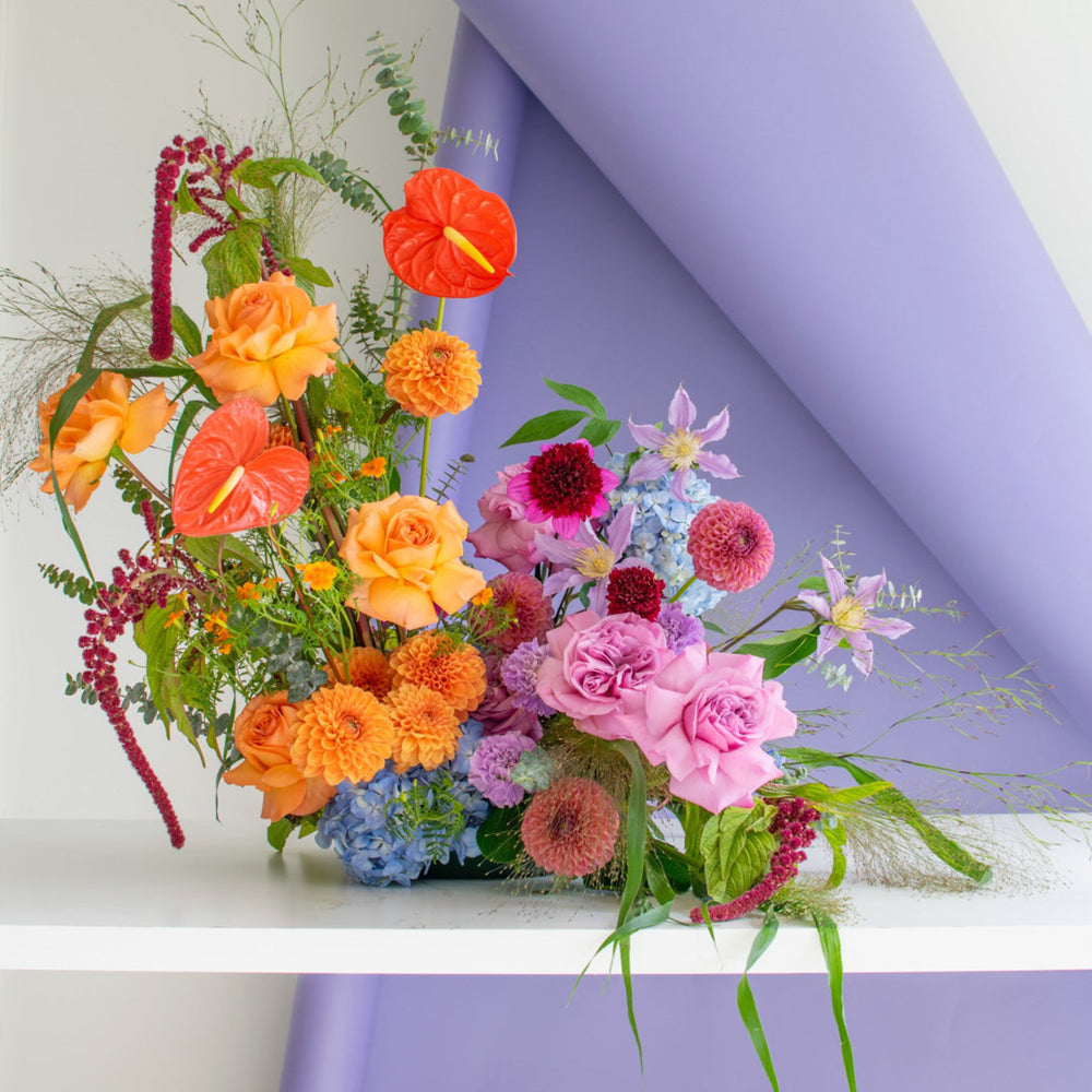 An asymmetrical floral arrangement in a bright warm palette.