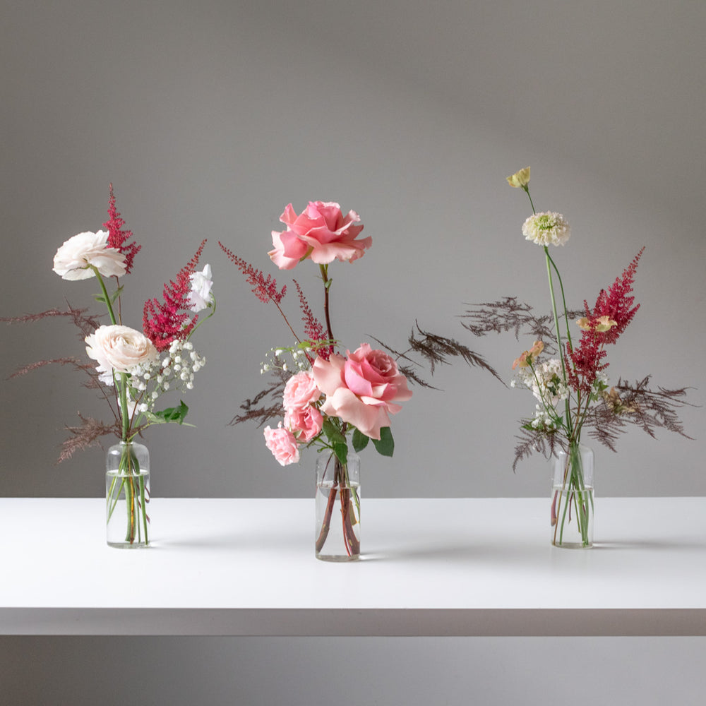 Three mini bud arrangements with pink roses and ranunculus.