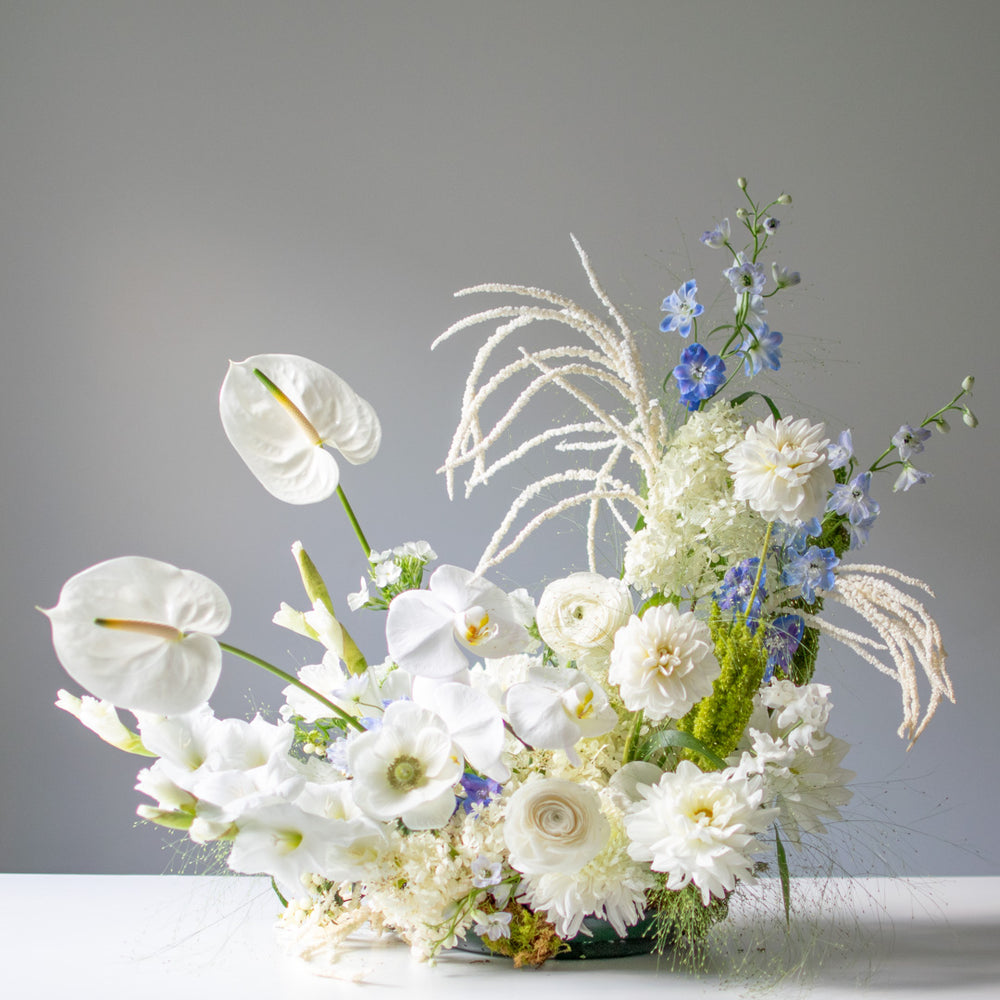 A large fresh flower arrangement with white anthuriums.
