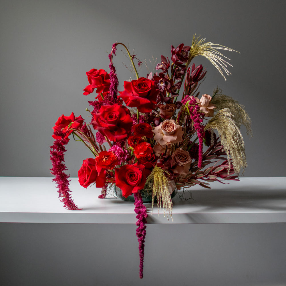 A large red floral arrangement for weddings with neutral accents.