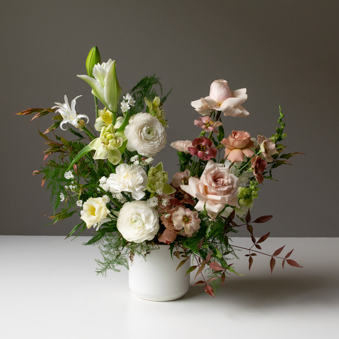 A two toned floral arrangement with light oranges, blues, and bold purples.