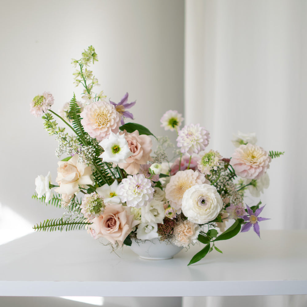 Soft pink and white flowers in a traditional wedding arrangement. Lots of dahlias and roses are used.