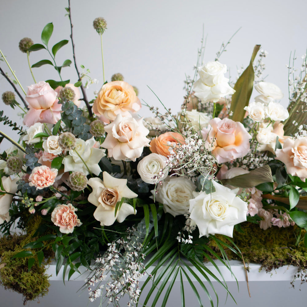 A soft, natural floral arrangement with lots of roses and wildflowers.