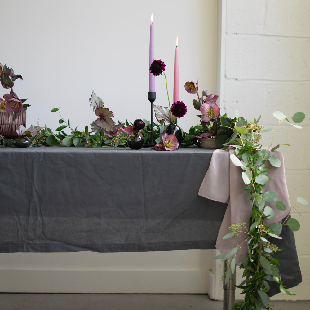 Greenery drapes off the side of this floral tablescape. 