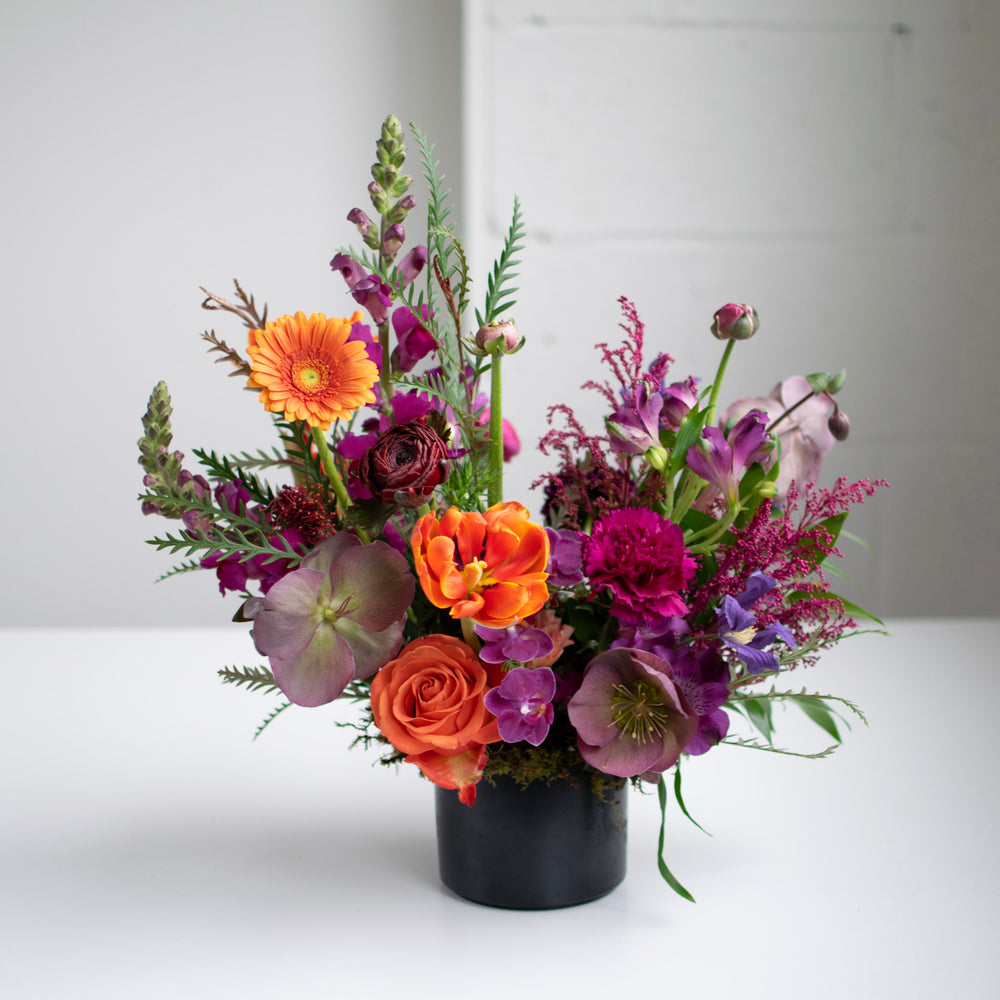 bright and bold arrangement in a black vase