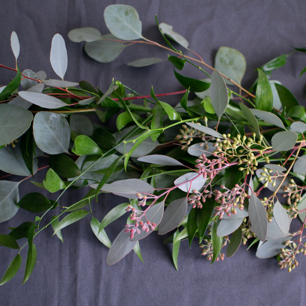 A close-up of various fresh greenery in a table runner.