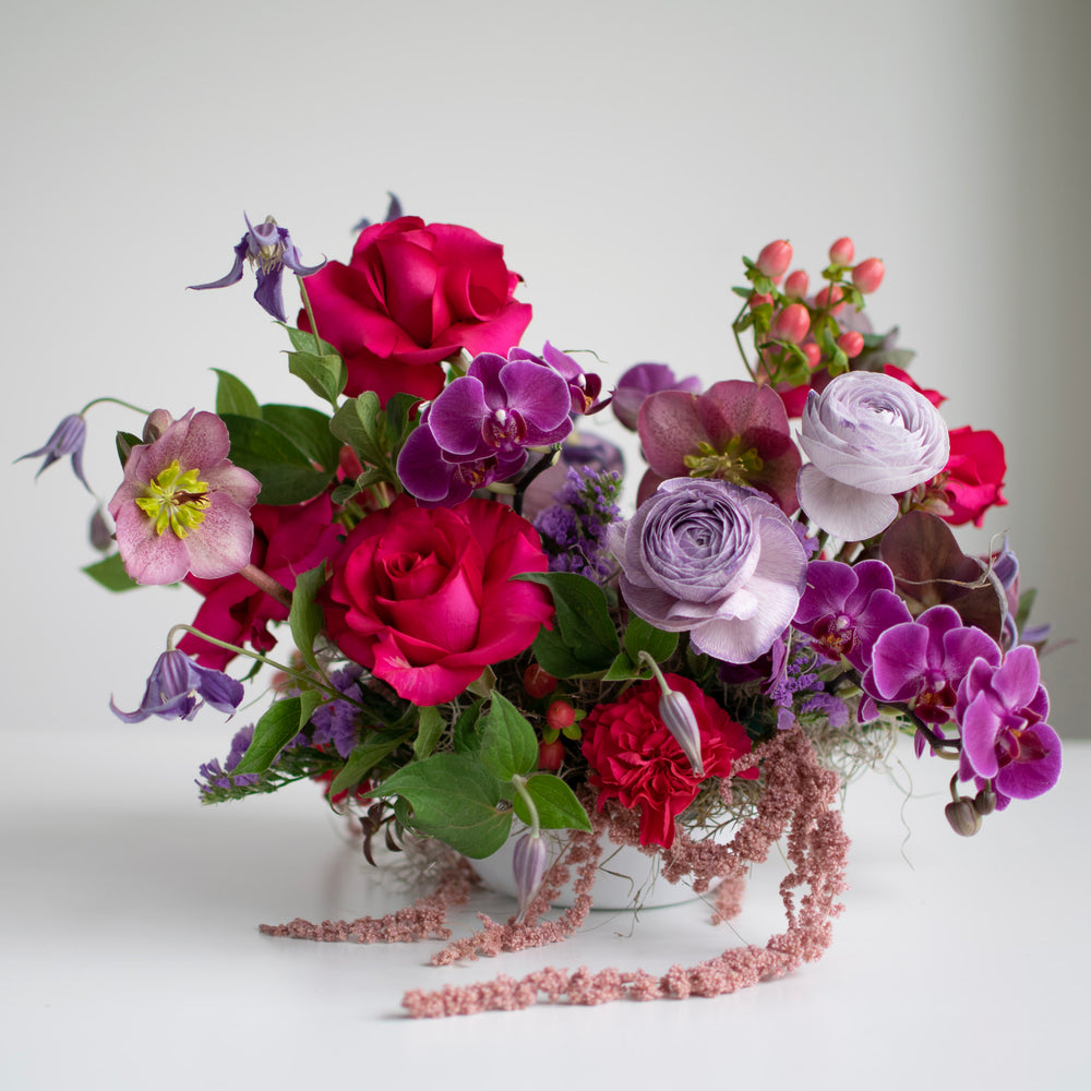 A bright and bold flower bouquet with purple orchids and hot pink roses.