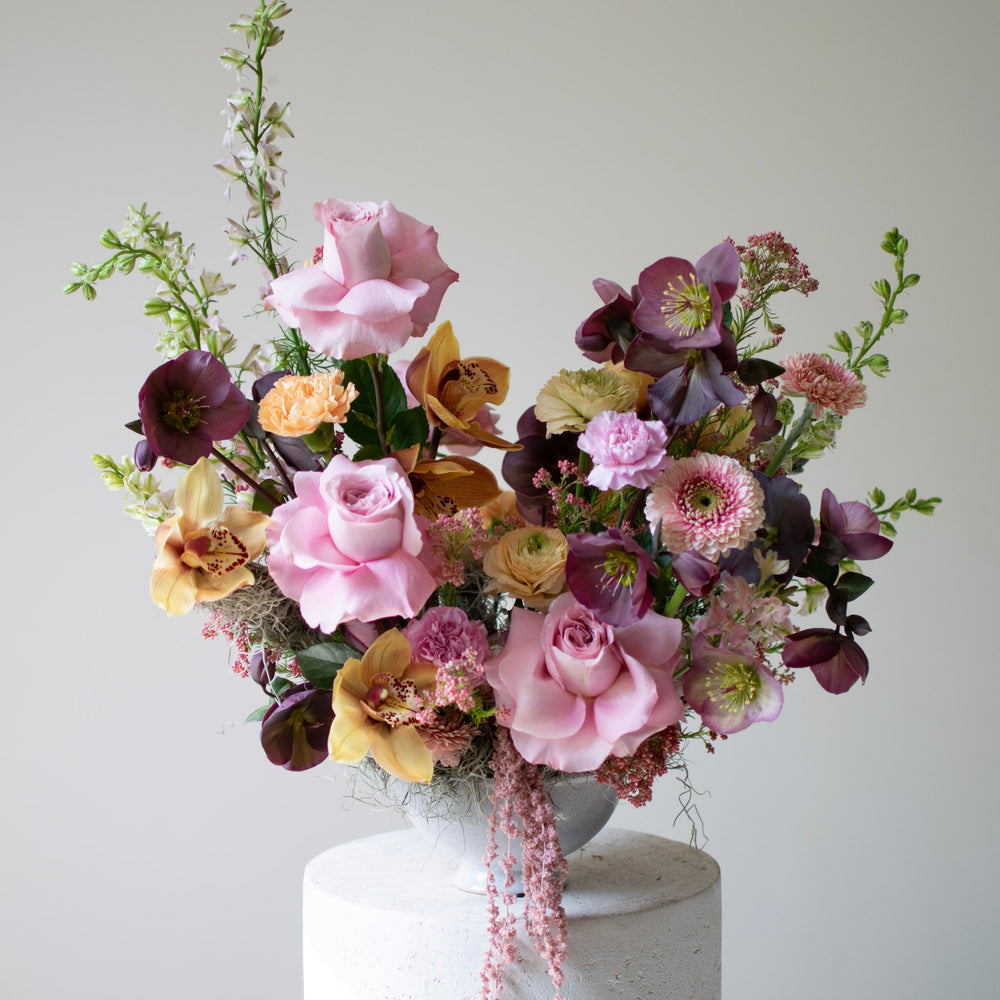 A pink floral arrangement with neutral accents.