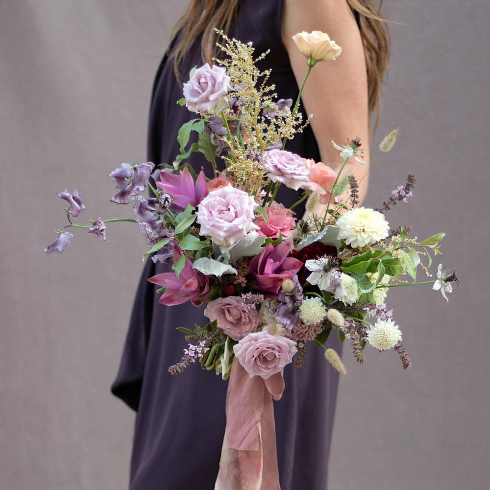 A large, lush bridal bouquet in mauve and creams.
