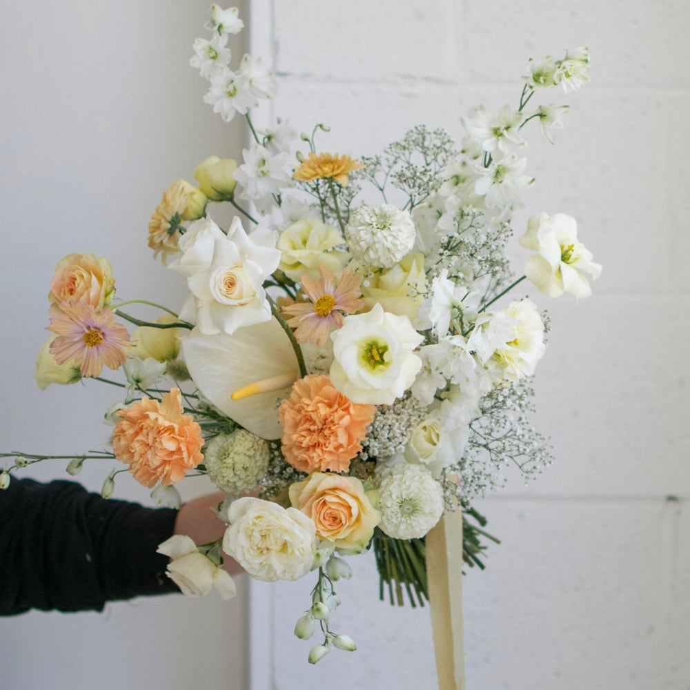 A large bridal bouquet with whites, cream and peach.
